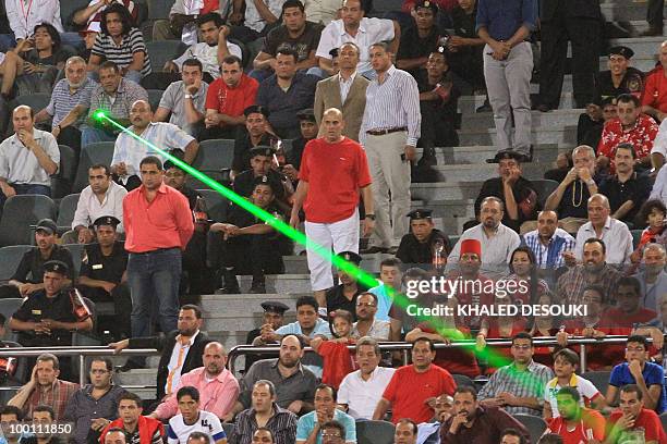 An Egyptian Al-Ahly's fan directs a laser light over the Libyan Al-Ittihad goalkeeper Samir Aboud during their African Champions League third round...