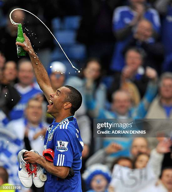 Chelsea's Ashley Cole celebrate with a bottle of beer as he runs around the pitch after Chelsea win the title with a 8-0 victory over Wigan Athletic...