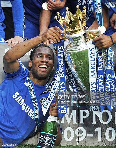 Chelsea's Ivorian striker Didier Drogba celebrates with the Premier league trophy after they win the title with a 8-0 victory over Wigan Athletic in...