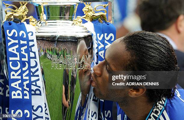 Chelsea's Ivorian striker Didier Drogba kisses the Premier league trophy after they win the title with a 8-0 victory over Wigan Athletic in the...