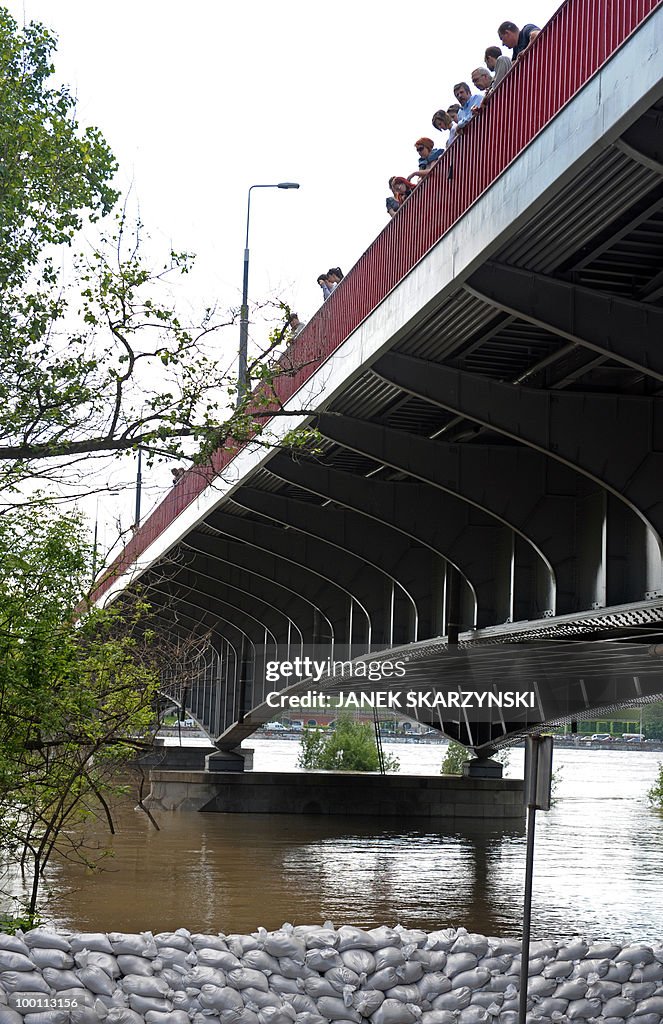 People watch from a bridge the high wate