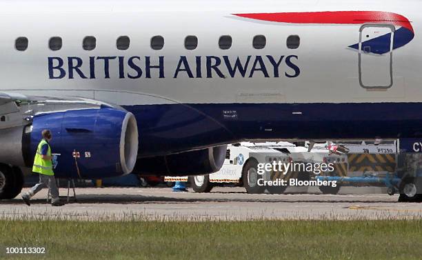 Member of the airport ground crew inspects a British Airways airplane at City Airport in London, U.K., on Friday, May 21, 2010. British Airways Plc...