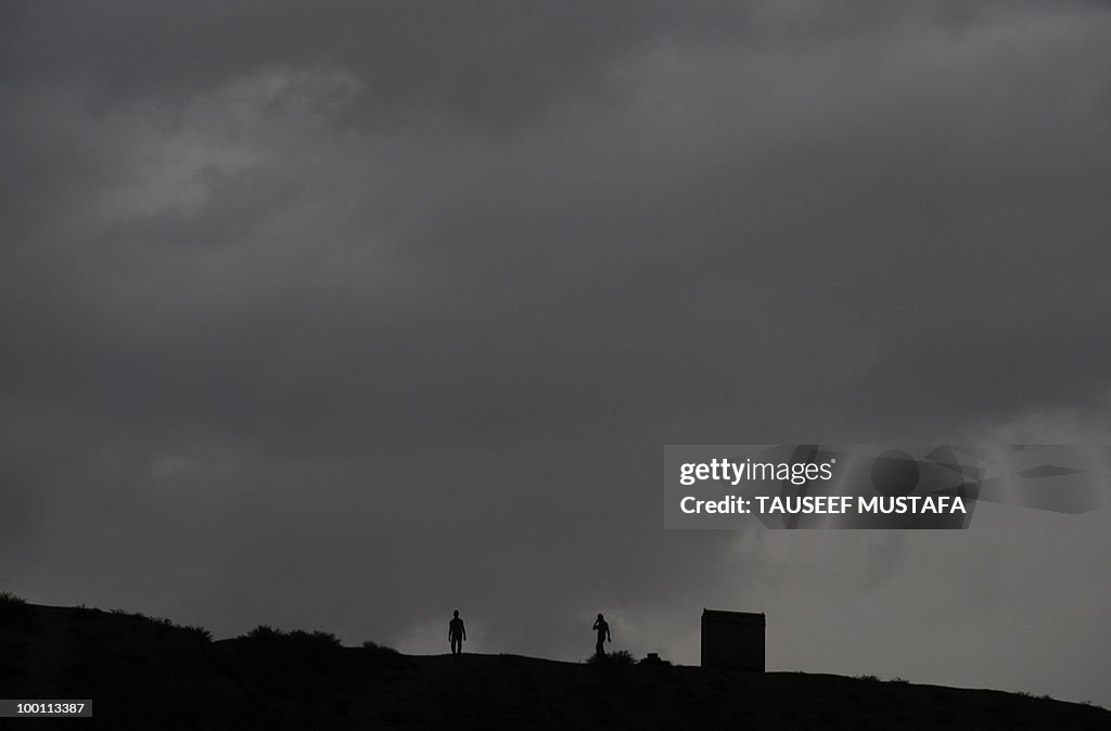 Afghan people walk on the top of a hill