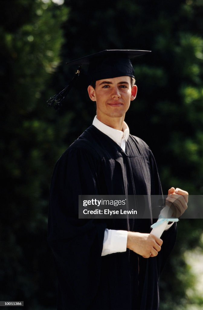 MALE GRADUATE WITH DIPLOMAOUTDOORS