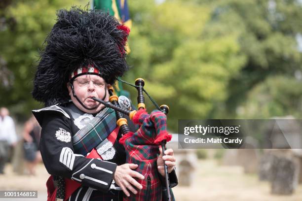 Piper Tosh McDonald plays the bagpipes as the coffin of World War 2 veteran Patrick Churchill in carried from the War Memorial on Church Green...