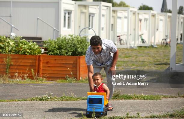 Afghan refugee Yashi and his toddler son Joseph play together inside a temporary refugee reception center at the former Tempelhof airport on July 18,...