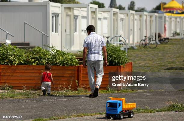 Afghan refugee Yashi and his toddler son Joseph play together inside a temporary refugee reception center at the former Tempelhof airport on July 18,...