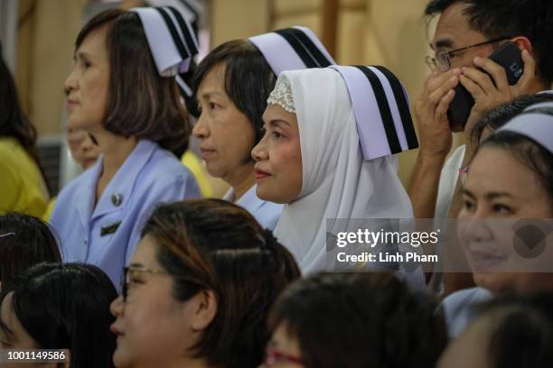 Volunteers react while hearing stories told by twelve boys and their coach from the 'Wild Boars' soccer team at a press conference for the first time...