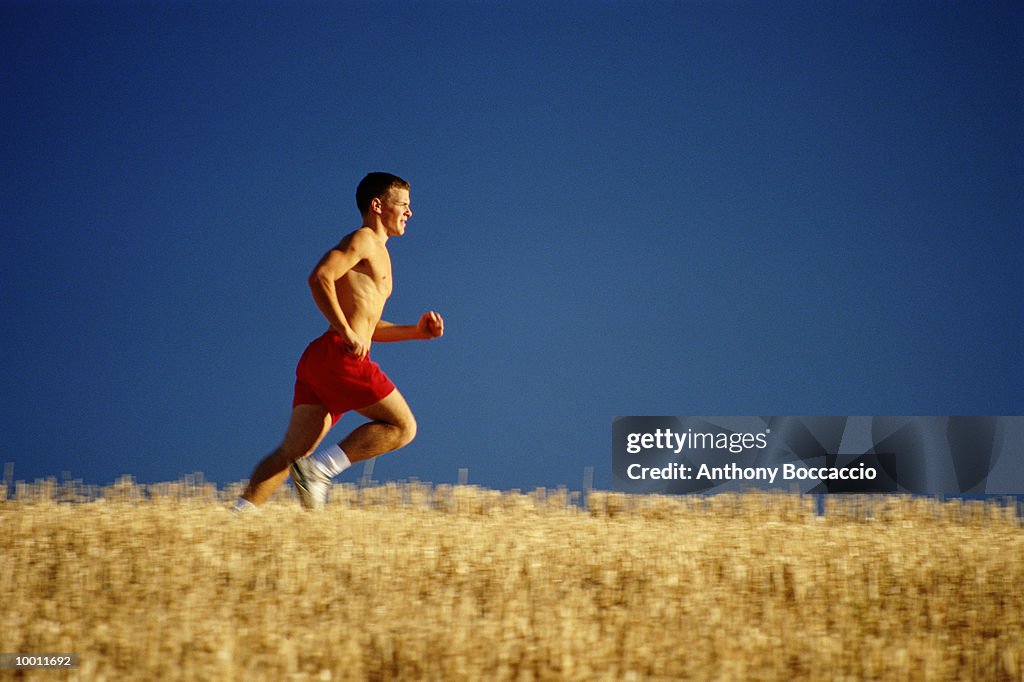 YOUNG MAN RUNNING IN WHEAT FIELD IN WASHINGTON