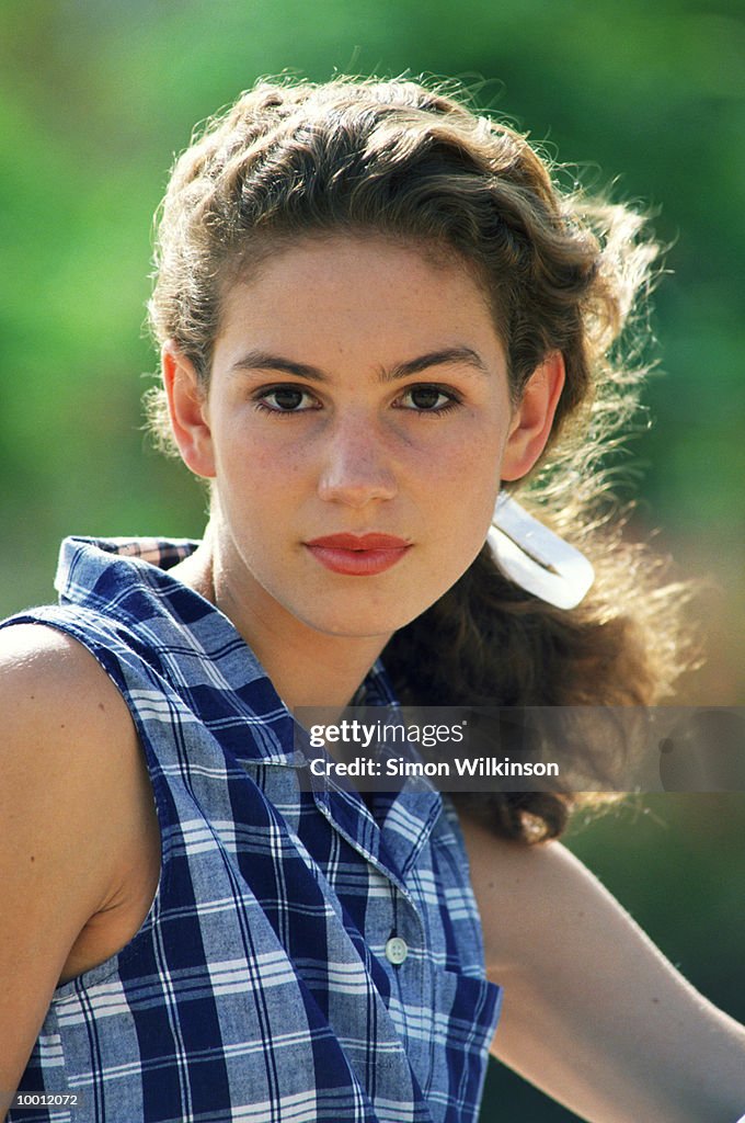 TEENAGE GIRL WITH HAIR PULLED BACK OUTDOORS