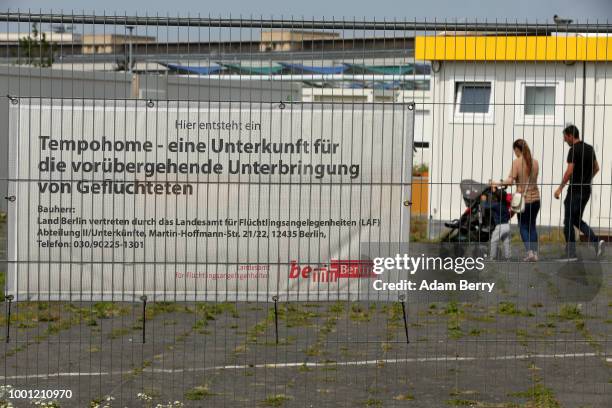 Refugee family walks through a temporary asylum seeker reception center at the former Tempelhof airport on July 18, 2018 in Berlin, Germany. Local...