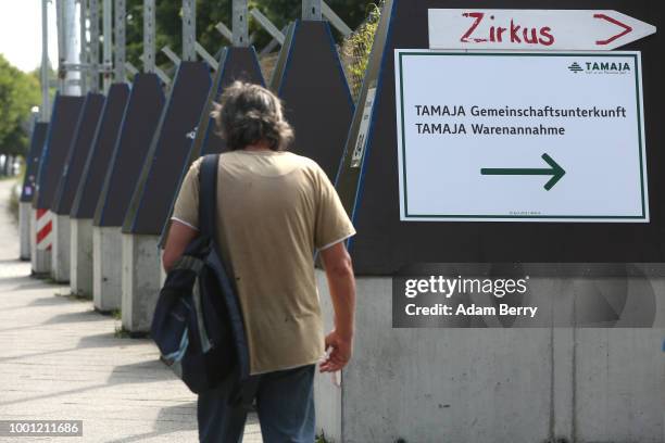 Pedestrian passes the entrance to a refugee reception center at the former Tempelhof airport on July 18, 2018 in Berlin, Germany. Local politicians...