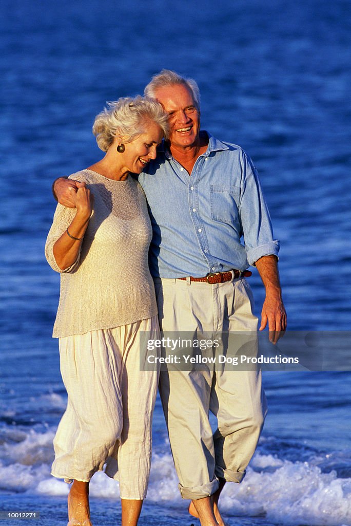 MATURE COUPLE WALKING ON BEACH