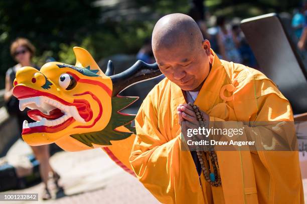 Buddhist monk prepares to bless a dragon boat during a traditional dragon boat awakening ceremony in Central Park, July 18, 2018 in New York City....