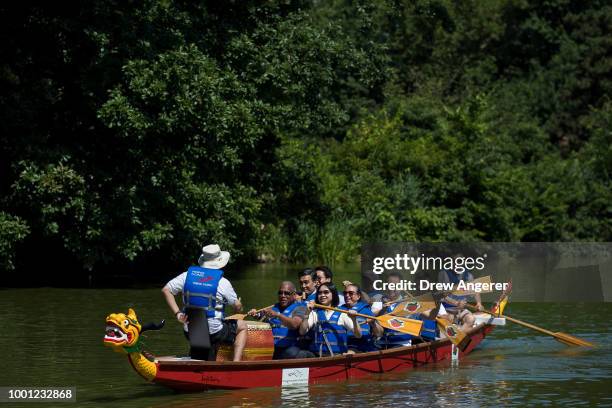 Led by New York City Parks Department Commissioner Mitchell Silver, a group paddles a dragon boat during a traditional dragon boat awakening ceremony...