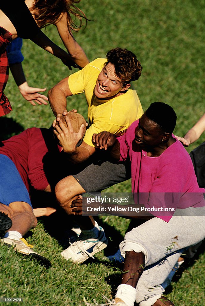 MULTI-ETHNIC YOUNG MEN PLAYING FOOTBALL