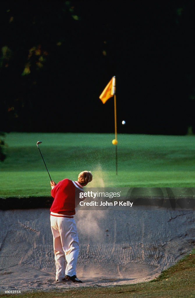 BACKVIEW OF A GOLFER IN SAND TRAP
