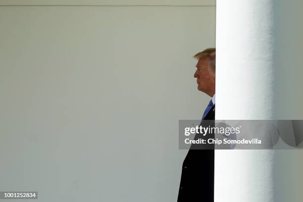 President Donald Trump walks along the Rose Garden colonnade after he and first lady Melania Trump returned to the White House July 18, 2018 in...