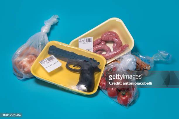gun shrinkwrapped for sale with food at a supermarket - gun control stock pictures, royalty-free photos & images