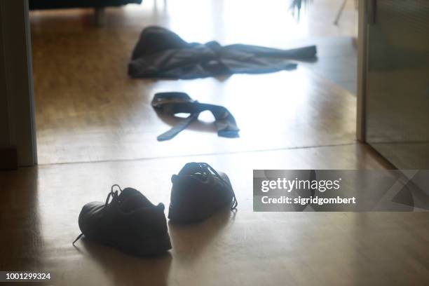 shoes, jacket and tie on the floor in the hallway - entkleiden stock-fotos und bilder