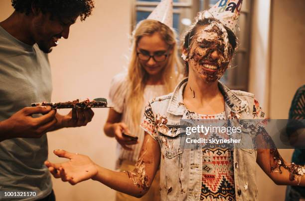 happy woman with birthday cake all over her face in the office. - cake face imagens e fotografias de stock