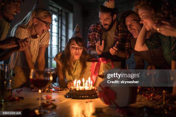 年輕女子在辦公室的生日聚會上吹蠟燭。 - birthday cake lots of candles 個照片及圖片檔