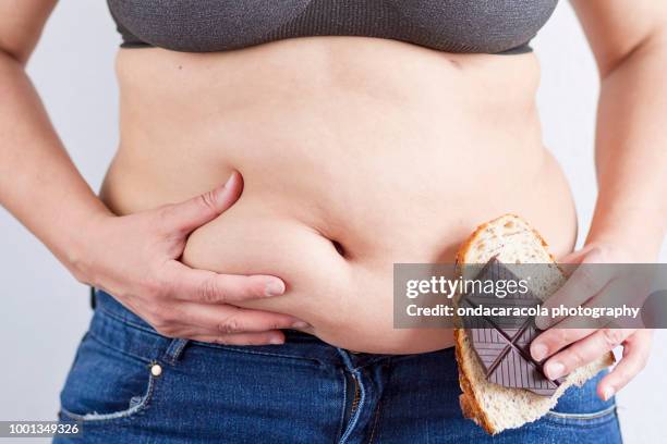 a woman with overweight showing her belly - belly fat stock pictures, royalty-free photos & images