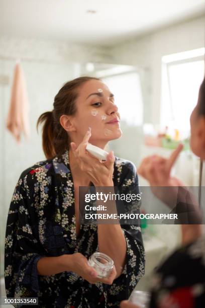 mujer en el baño - crema facial fotografías e imágenes de stock