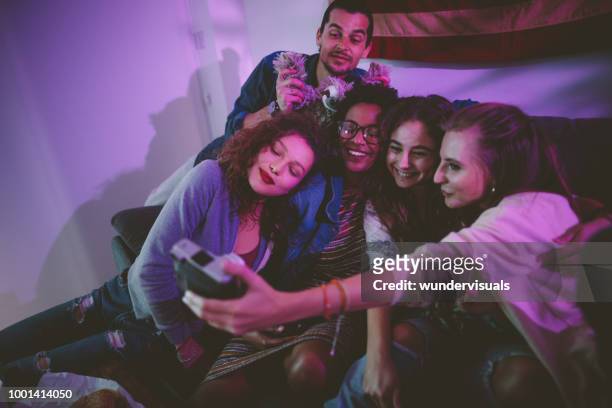 lächelnd multiethnischen freunde nehmen selfie zu hause mit vintage-kamera - college dorm party stock-fotos und bilder