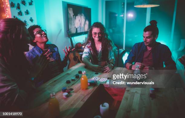 multi-ethnischen hipster freunde spielkarten spiel an college wohnheim party - college dorm party stock-fotos und bilder