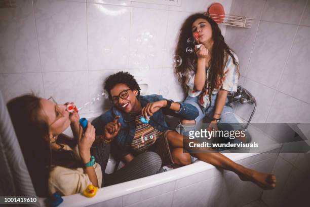 junge teenager-mädchen albern und spaß seifenblasen - college dorm party stock-fotos und bilder