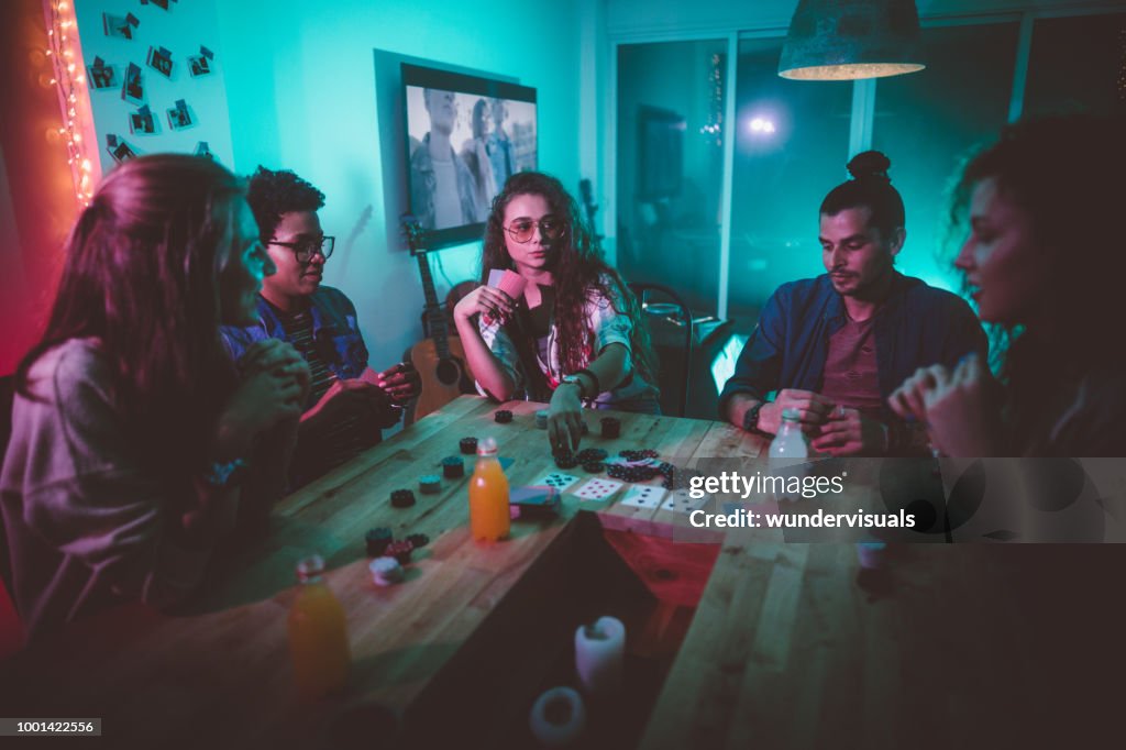 Multi-ethnic hipster friends playing poker at home