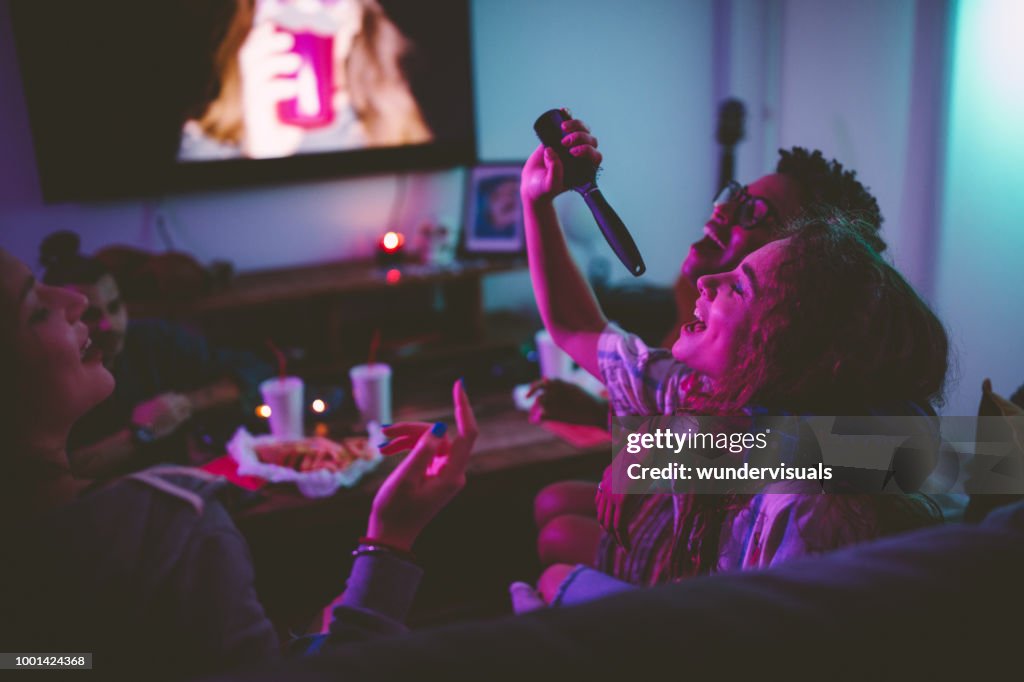 Multi-ethnic teenage girls having fun singing at slumber party