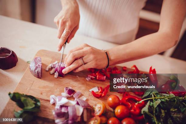 kvinnan skära lök och grönsaker på skärbräda - mediterranean diet bildbanksfoton och bilder