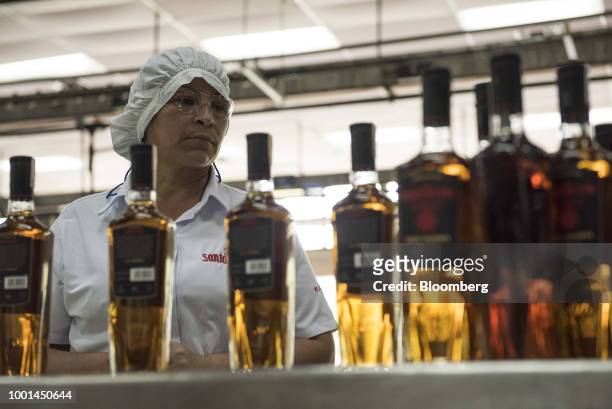 An employee inspects bottles of rum at the Ron Santa Teresa SACA distillery in El Consejo, Aragua state, Venezuela, on Tuesday, July 17, 2018. Once...