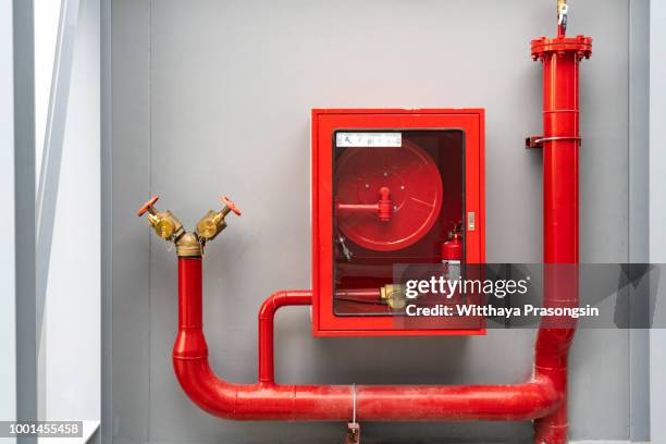 fire extinguisher and fire hose reel in hotel corridor - impianti antincendio foto e immagini stock