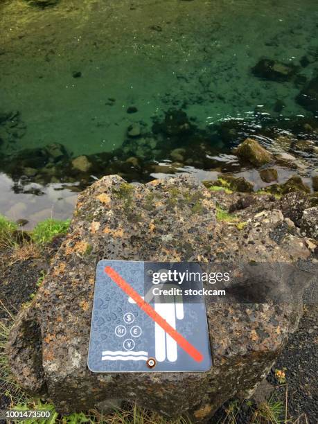 touristischen gebeten, nicht werfen ein paar cent im fluss öxará, island - river island sighn stock-fotos und bilder