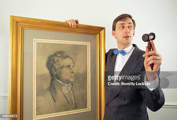 auctioneer with gavel & old painting - auctioneer stock-fotos und bilder