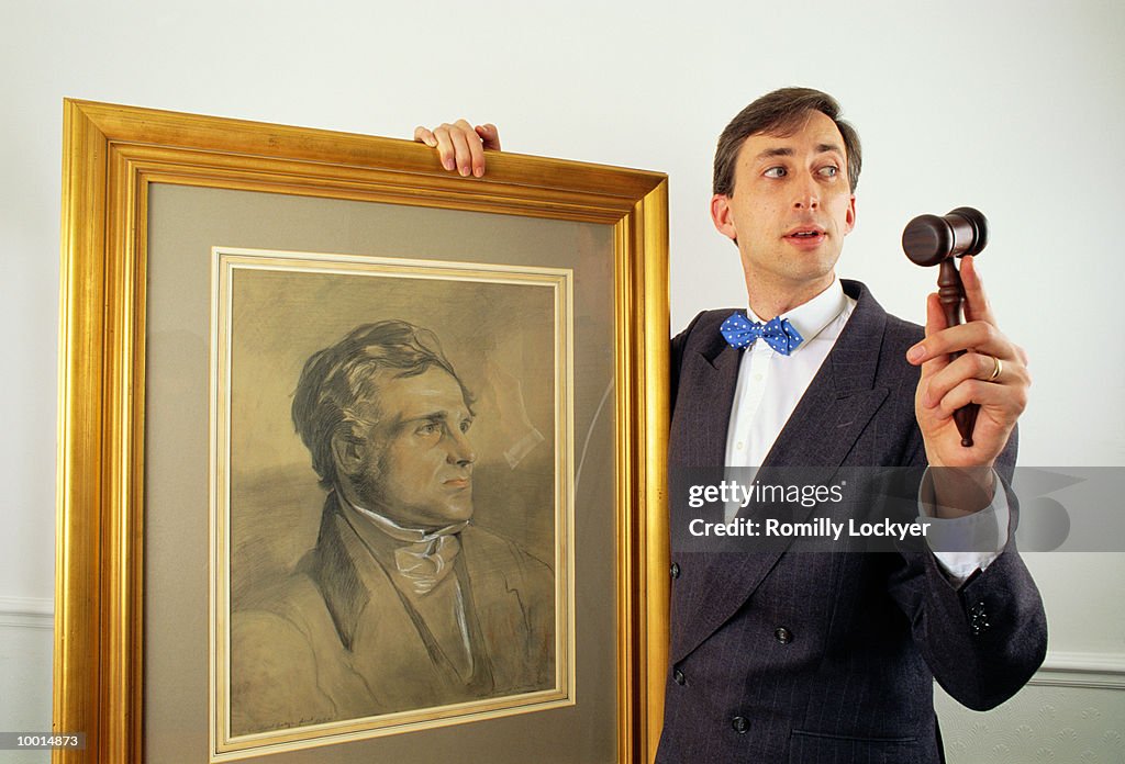 AUCTIONEER WITH GAVEL & OLD PAINTING