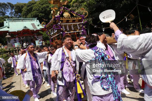 Participants carry a portable shrine during the Kainan Shrine summer festival in the Misakimachi area of Miura, Japan, on Saturday, July 14, 2018....