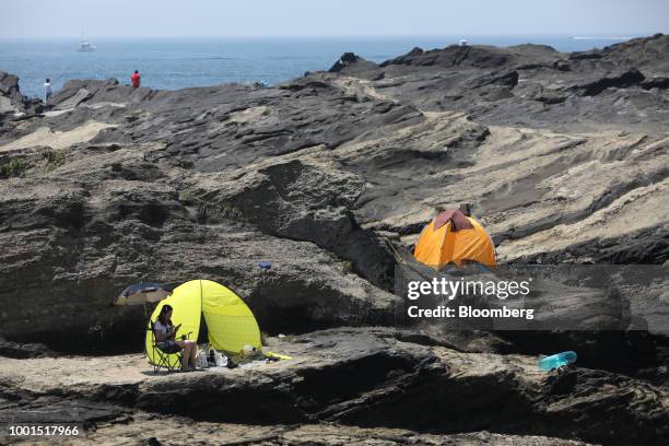 Tents stand at a rocky shore on Jogashima island in the Misakimachi area of Miura, Japan, on Saturday, July 14, 2018. Japan is scheduled to release...