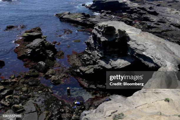 People stand near the "Umanose-doumon" rock formation, also known as horseback cave, on Jogashima island in the Misakimachi area of Miura, Japan, on...