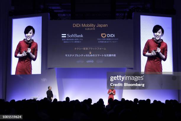 Jean Liu, president of Didi Chuxing, right, speaks as Masayoshi Son, chairman and chief executive officer of SoftBank Group Corp., looks on at the...