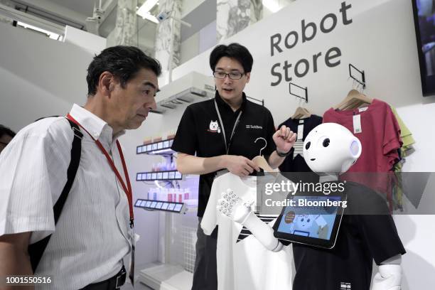 An attendee interacts with a SoftBank Group Corp. Pepper humanoid robot at the SoftBank World 2018 event in Tokyo, Japan, on Thursday, July 19, 2018....