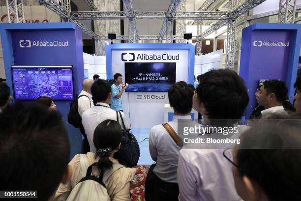 Attendees listen to an attendant explaining about cloud computing services by Alibaba Cloud, a subsidiary of Alibaba Group Holding Ltd., at the...
