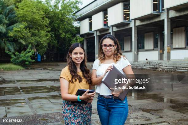 dos estudiantes hispanos orgullosamente de pie fuera de su universidad en cali colombia - cali colombia fotografías e imágenes de stock