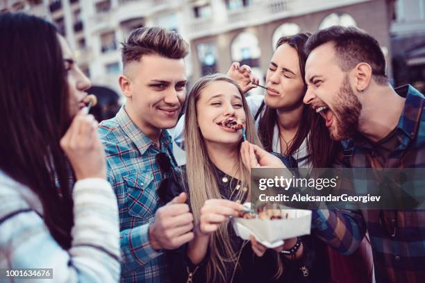 group of crazy friends eating donuts and having fun together in city center - friends donut stock pictures, royalty-free photos & images