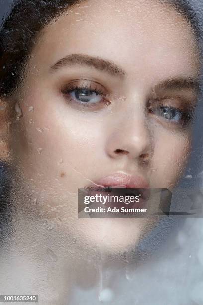 beautiful face of a woman behind an iced window - pneumonia mask stock pictures, royalty-free photos & images