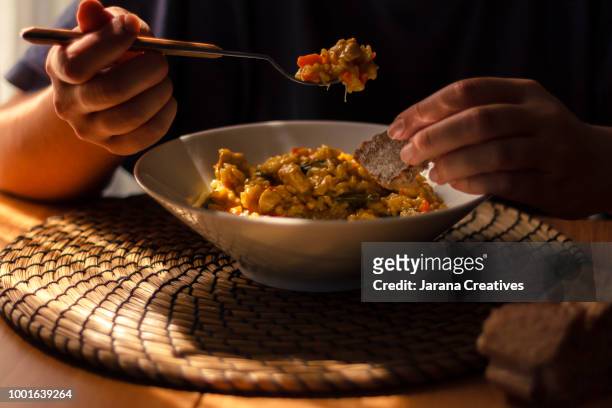 woman eating rice - comida básica fotografías e imágenes de stock