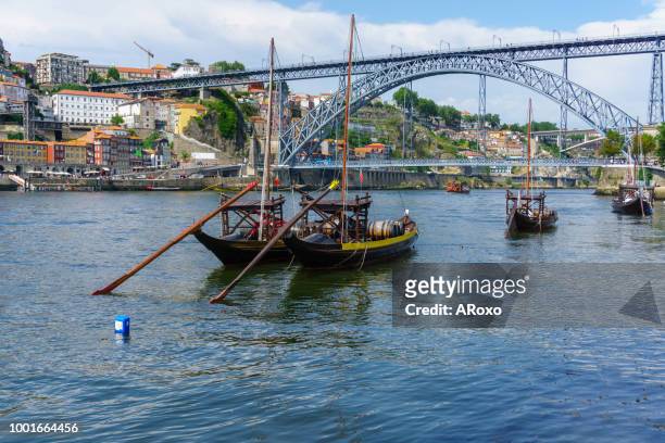 typical boats of the douro river in oporto. panoramic views of the historic city center of porto in portugal. - ribeira porto stock pictures, royalty-free photos & images